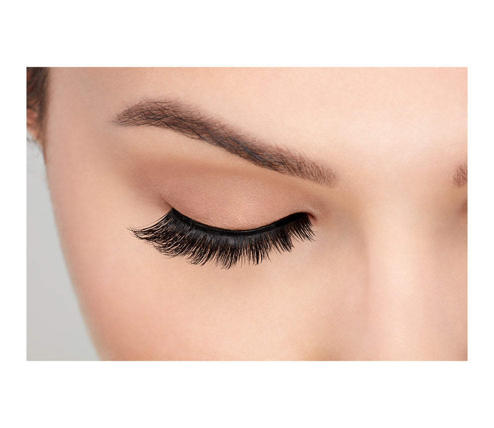 A model wearing Ardell's Faux mink 852 with open right eye showing its staggering length & natural appearance
