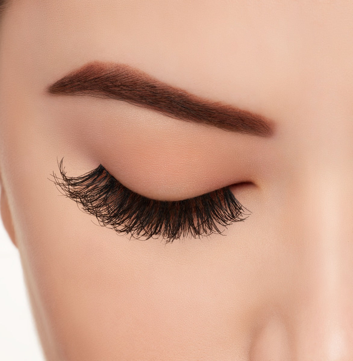 A close-up side shot of a model's eye wearing Ardell's Wispies 704 creating A natural, round flared eyelash look