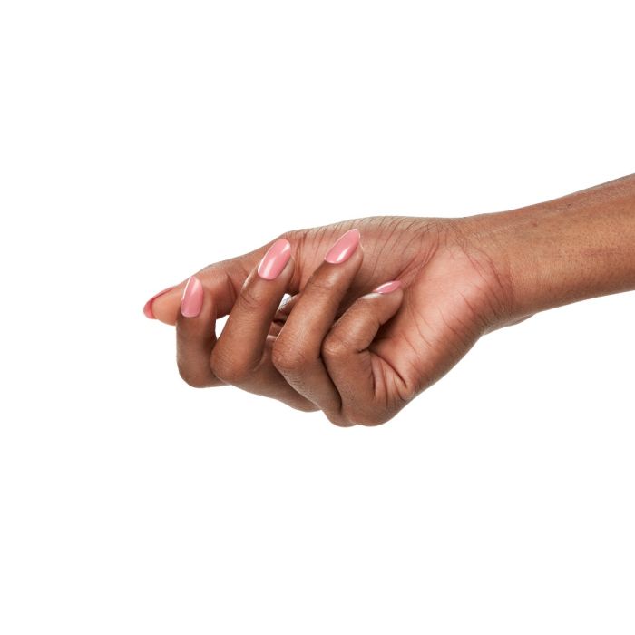 Model hand with short, glossy nails painted in Ardell Impeccable rosy nude gel polish.