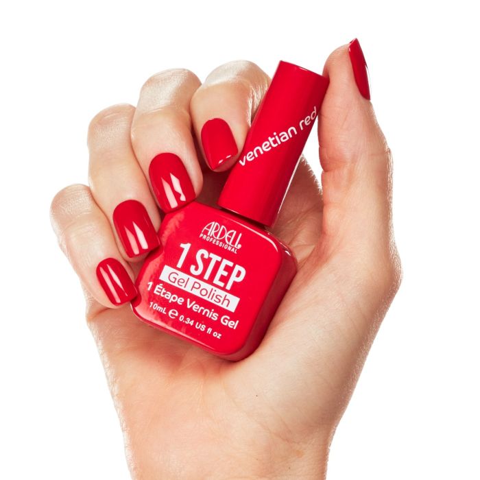 Model hand in Ardell Venetian Red polish, a polished and timeless red manicure with full coverage.