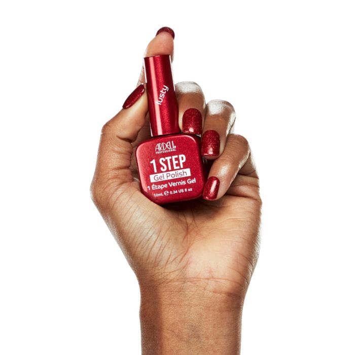 Model hand in Ardell Lusty polish, showcasing a striking red manicure with a shimmering gel effect.