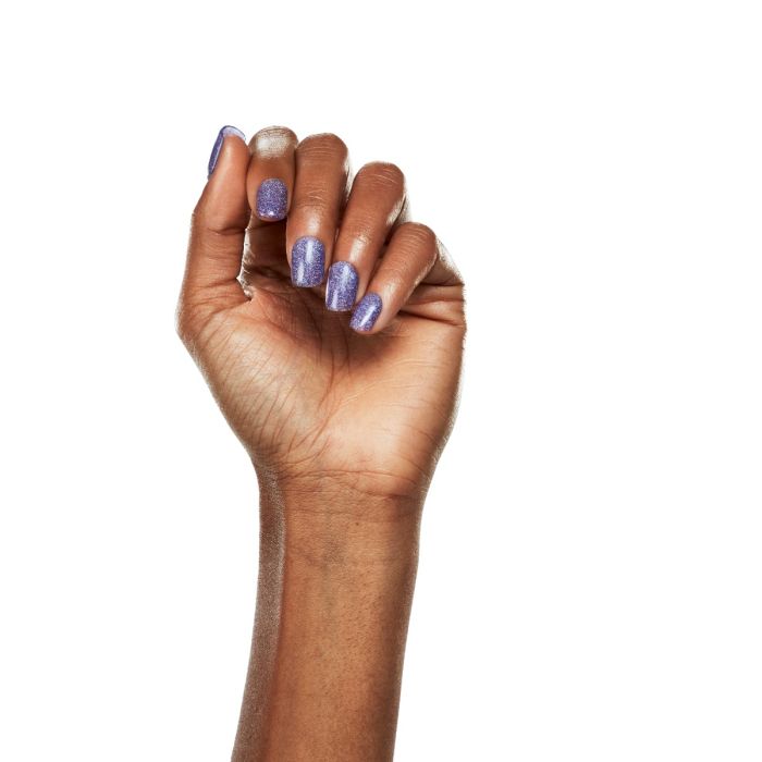 Natural hand shot in Ardell Enchantment gel polish, a dreamy lavender look with scattered white sparkle.