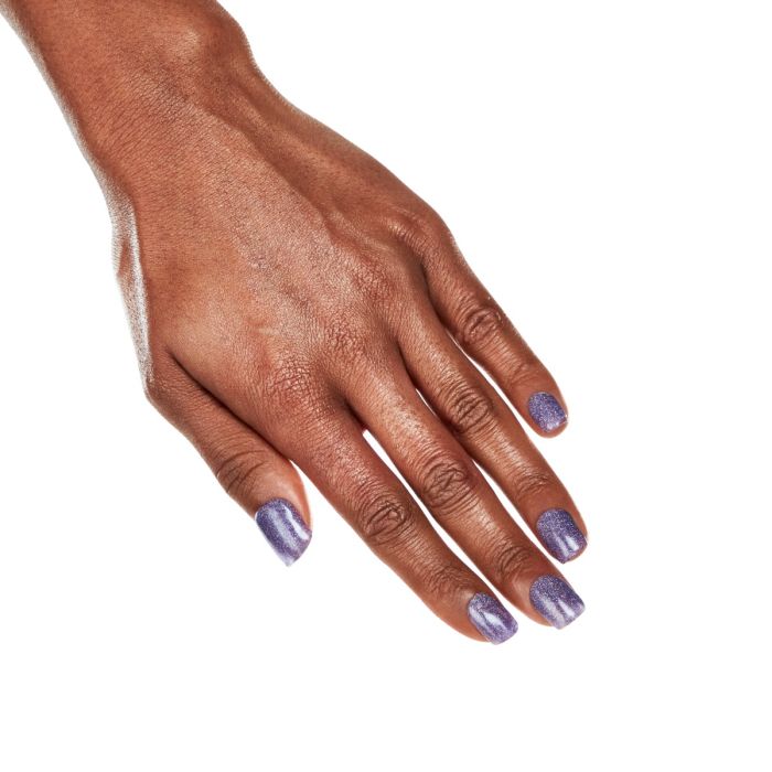 Side hand pose in Ardell Enchantment polish, revealing a unique pastel purple manicure with glitter specks.
