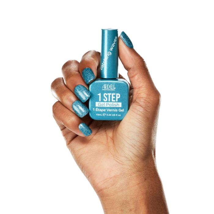 Model hand wearing Ardell Catching Waves gel polish, showing a bold, glossy turquoise shimmer manicure.