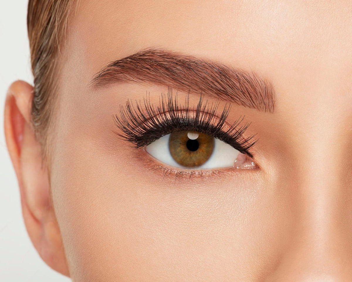 A model wearing Ardell's Double Up 207 with open right eye showing its extra-long layers with intense volume & fullness lash