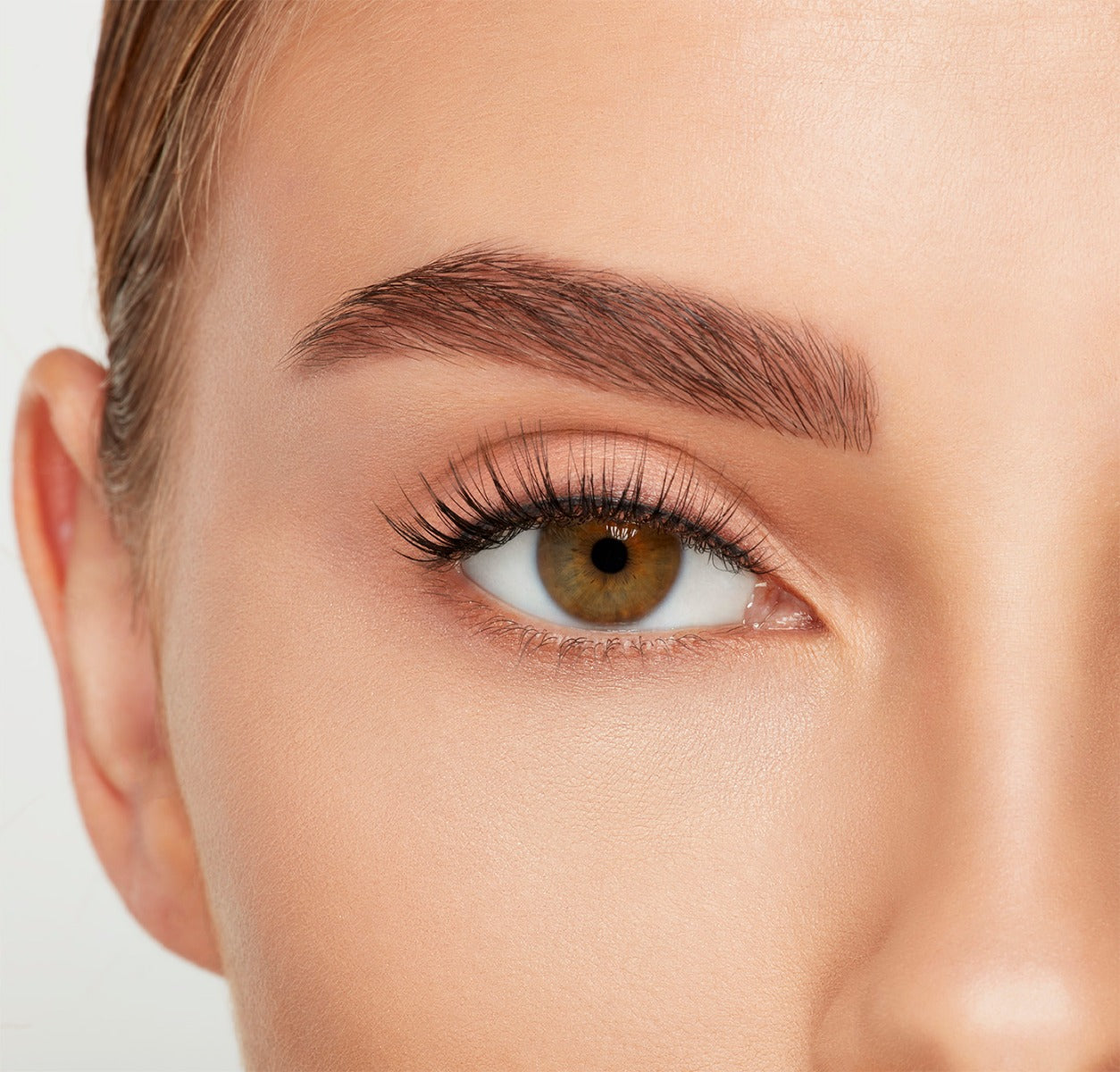 Close-up of a model's open right eye wearing an Ardell Lift Effect 744 false lash showing its airy elongated style