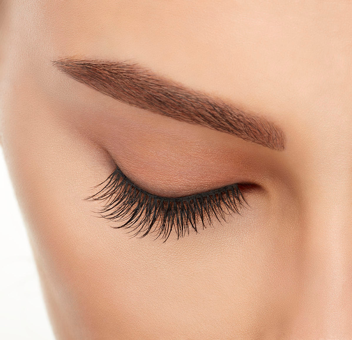 Close-up of a model's closed right eye wearing an Ardell Lift Effect 744 faux lash