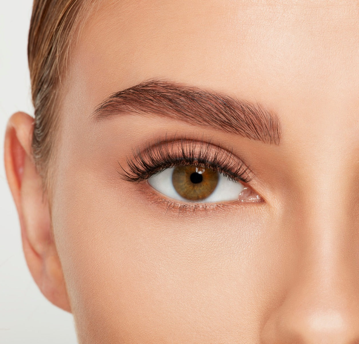 Close-up of a model's open right eye wearing an Ardell Lift Effect 745 false lash showing its airy elongated style