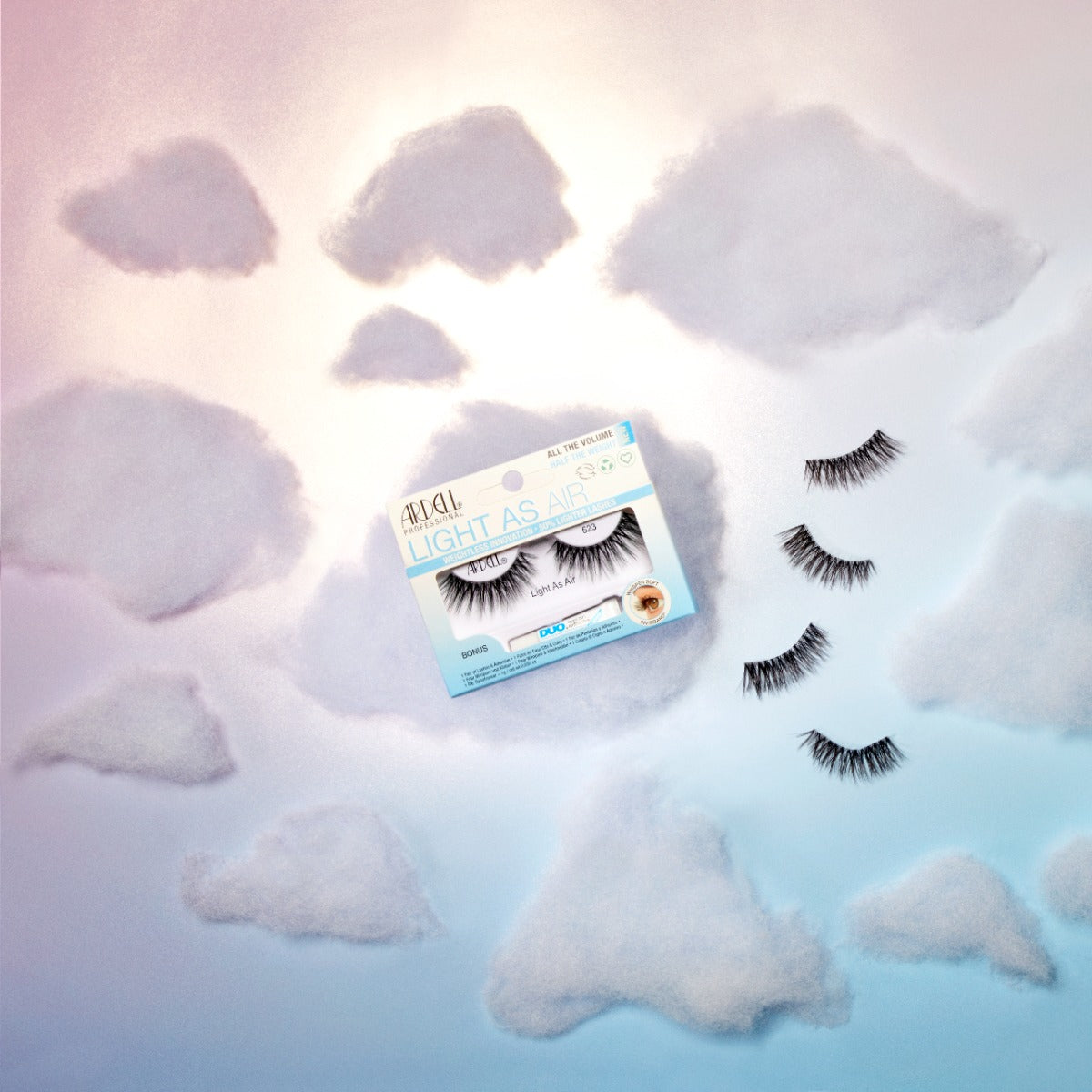 Ardell Light As Air 523 lashes displayed in a dreamy cloud-themed setting, highlighting their ultra-lightweight feel.