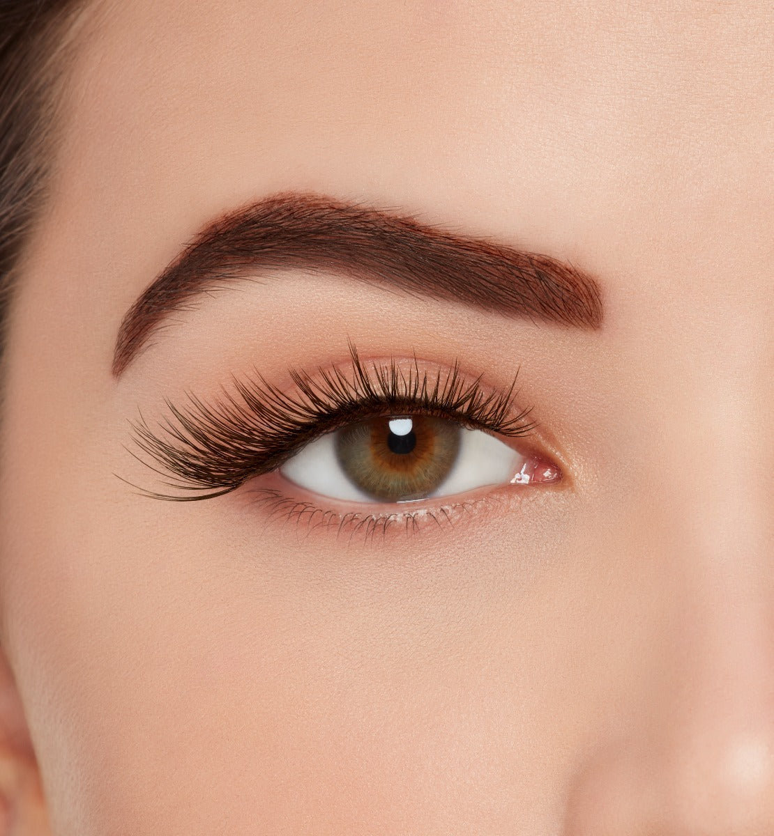 A model wearing Ardell's Light As Air 523 with full volume, staggered lengths and light criss crossing