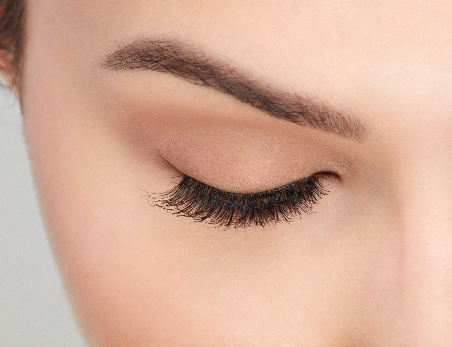 A beautiful woman with a close right eye wearing Ardell Natural 120 showing how it looks like when it's worn