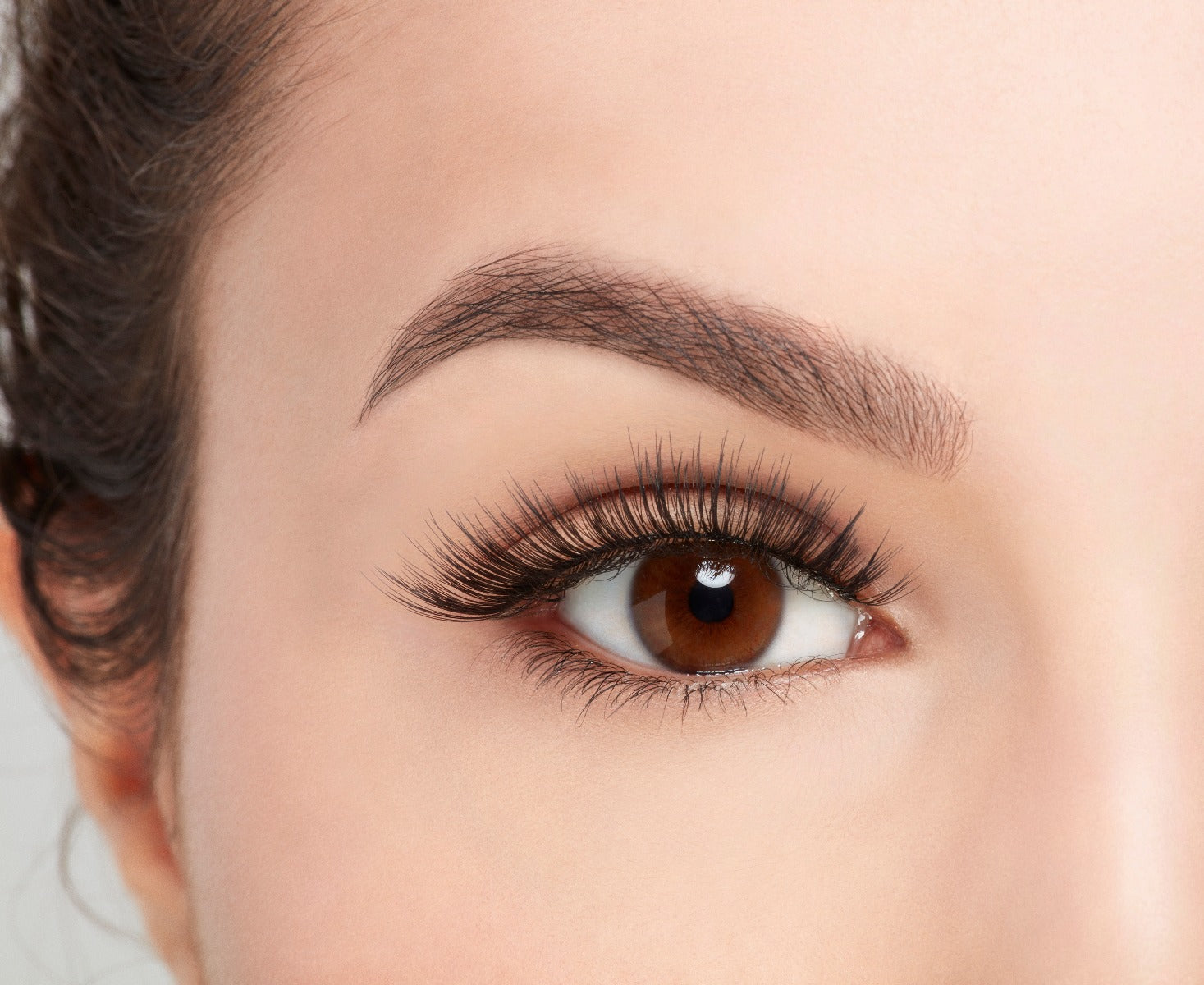 Close-up of a model's open right eye wearing an Ardell Soft Touch 152 false lash