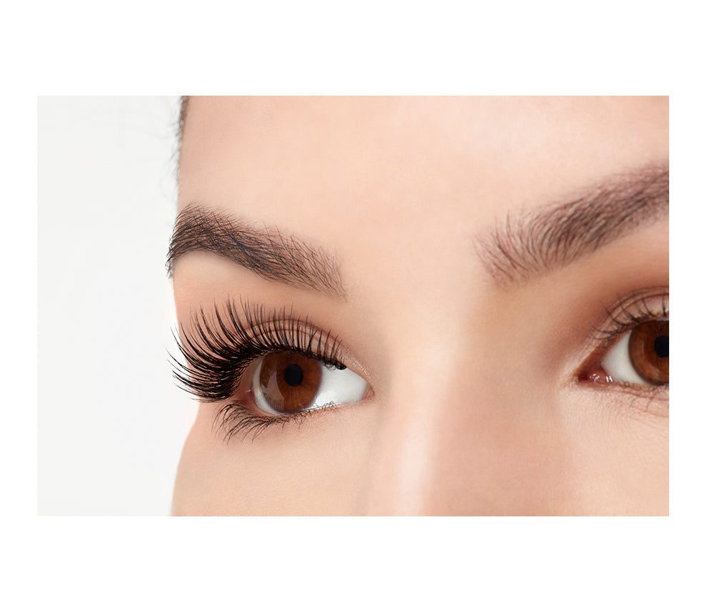 A close-up side shot of a model open right eye wearing Ardell Faux mink 812 showing a rounded, feathery yet natural lash look