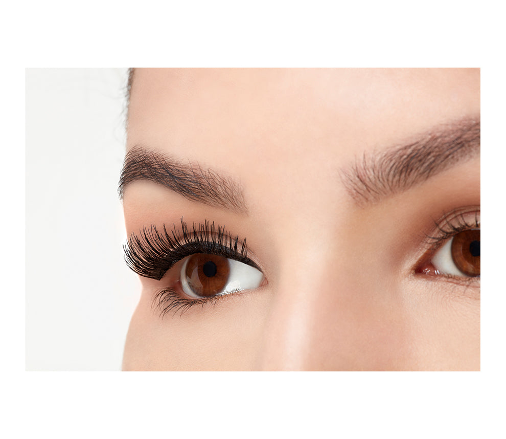Angled close-up of a model 's closed right eye wearing an Ardell Magnetic Double Demi Wispies false lash