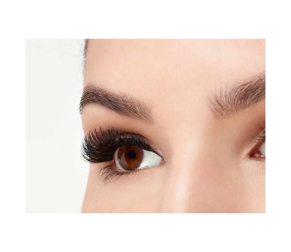 Angled close-up of a model's opened right eye wearing an Ardell Magnetic Double Demi Wispies false lash