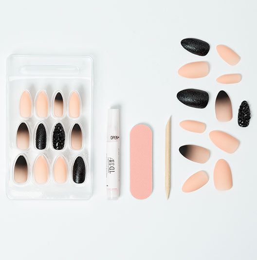 A complete artificial nails set & tools of black stud and pink ombre nail set laid separately in a white background