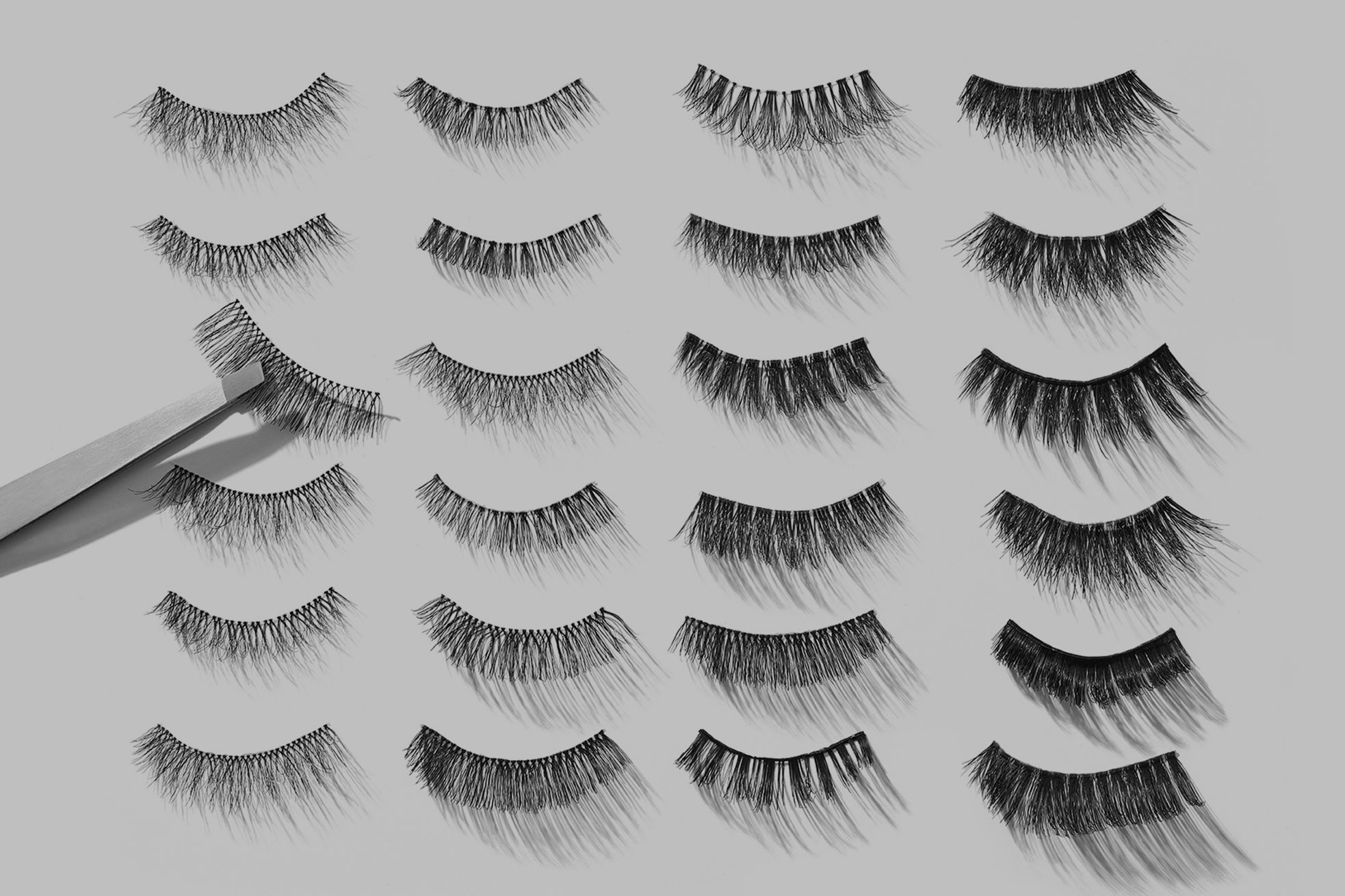 Set of false lashes displayed on a gray background