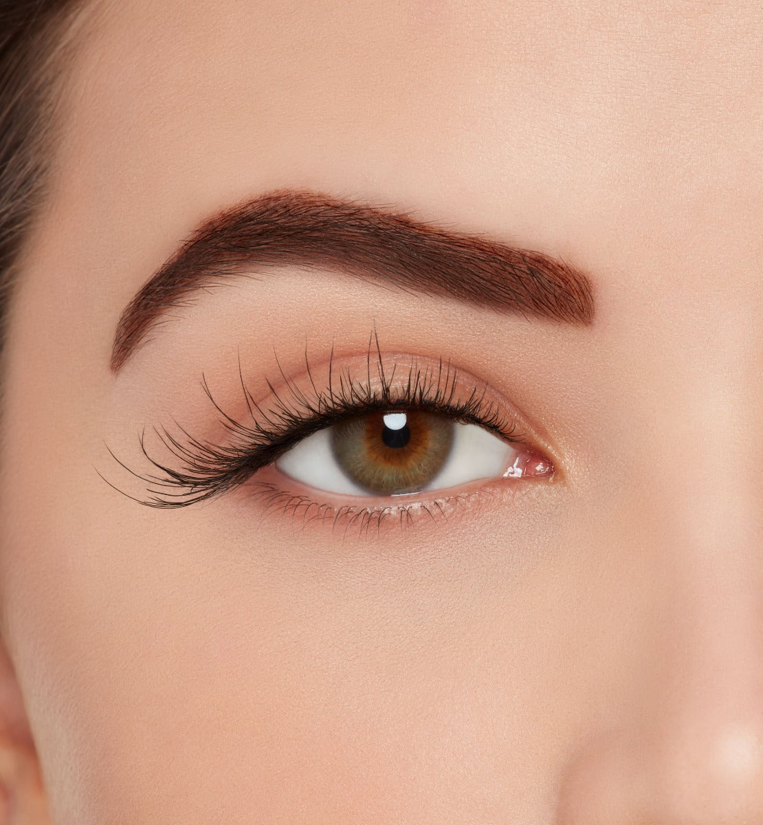 A model wearing Ardell's Wispies 702 to show lightly flared and fluttery lash with an open right eye