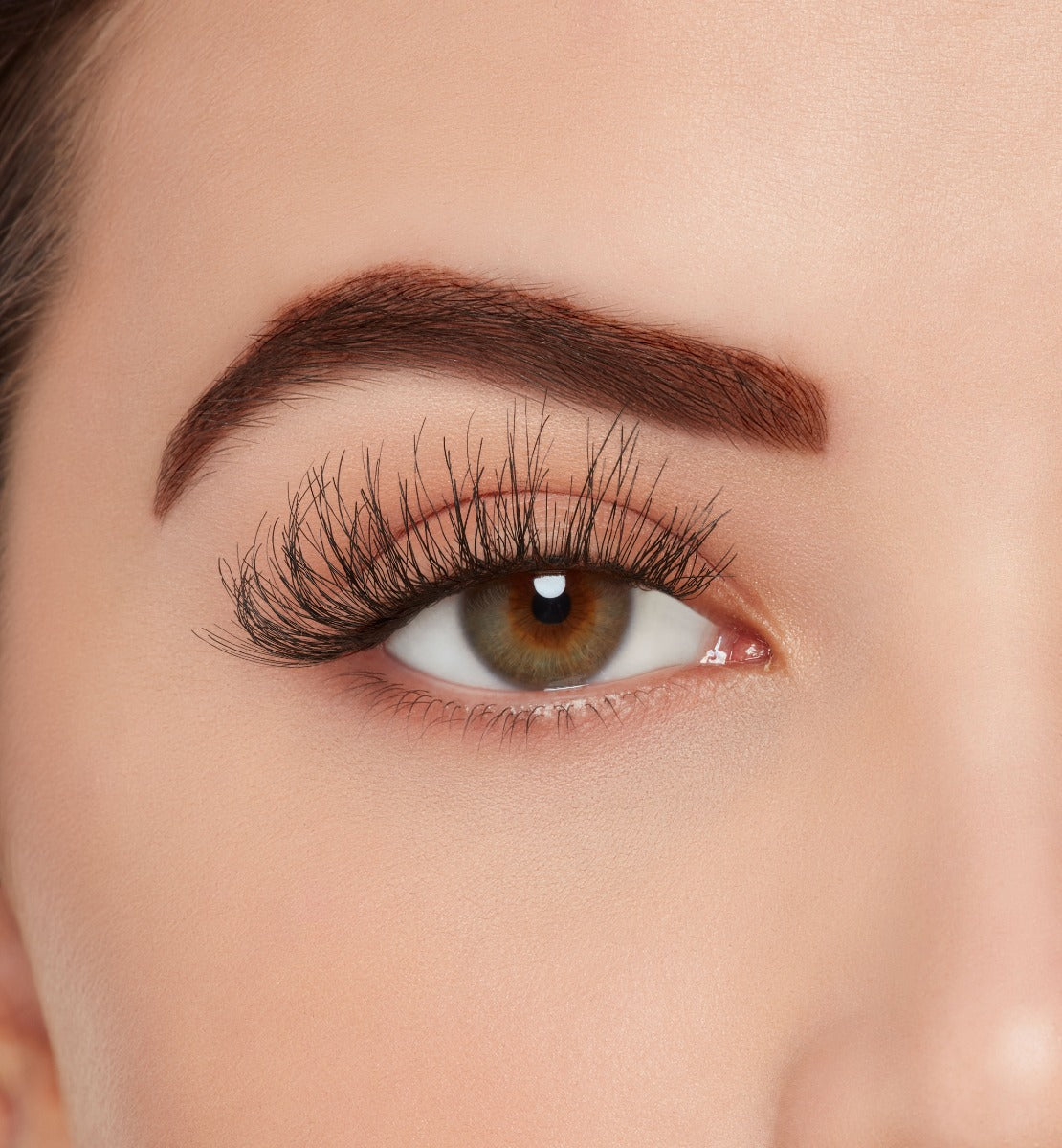 A model wearing Ardell's Wispies 704 to show lightly flared with an open right eye