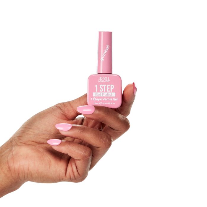 Manicured hand wearing Ardell Gumball, a vibrant bubblegum pink gel polish shade.