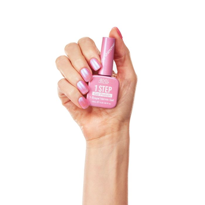 Hand holding Ardell 1 Step Gel Polish in Peony Shimmer, showcasing glossy pink shimmer nails with full bottle view.
