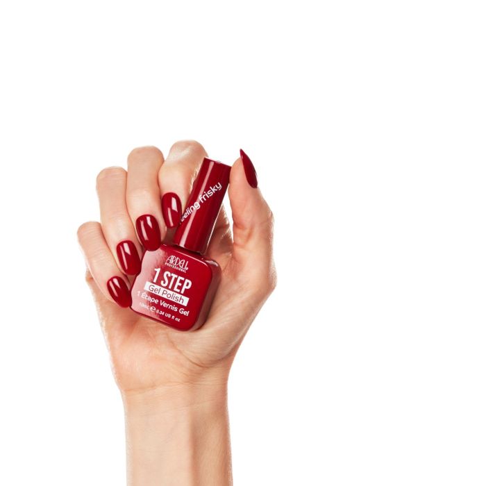 Hand model wearing Ardell Feeling Frisky polish, featuring a high-impact red manicure with a glossy crème finish.