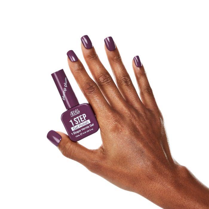 Model hand in Ardell Plump Plum polish, displaying a chic and sophisticated purple manicure.