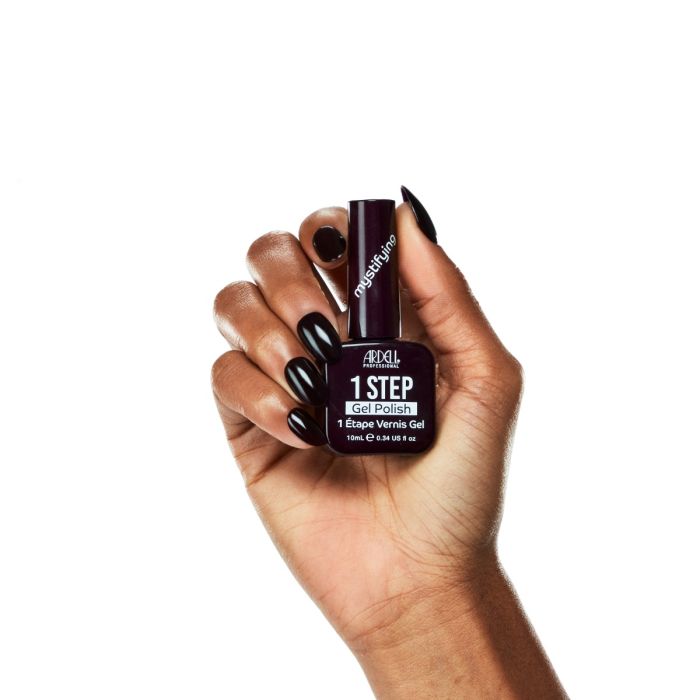 Model hand shot in Ardell Mystifying polish, featuring a bold, sophisticated deep wine red nail look.