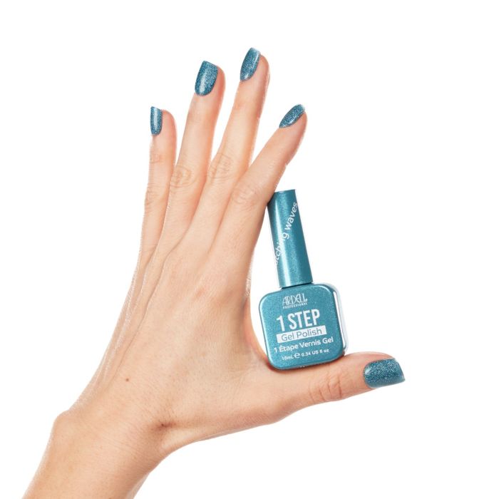 Close-up hand pose with Ardell Catching Waves polish, displaying a vivid turquoise shimmer gel finish.