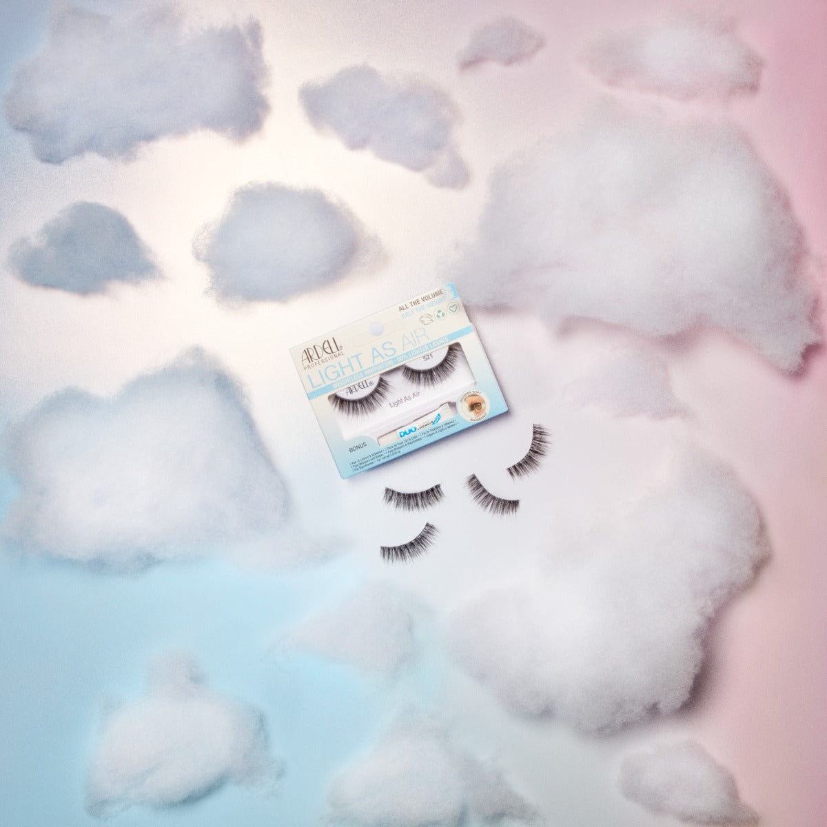 Ardell Light As Air 521 lash packaging surrounded by fluffy clouds, illustrating the lightness and comfort of the lashes.
