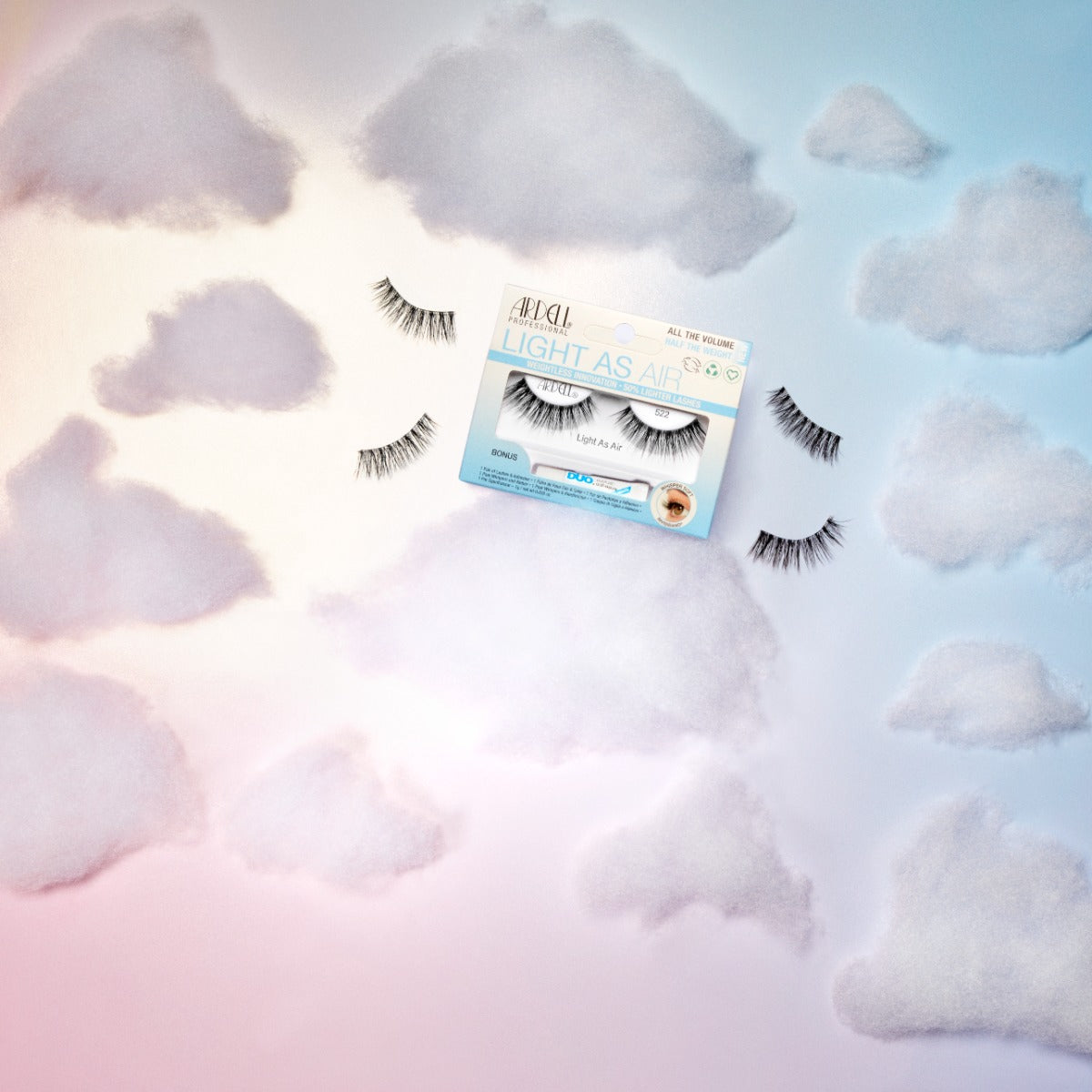 Ardell Light As Air 522 lashes presented in a pastel cloud background, emphasizing their weightless and airy effect.