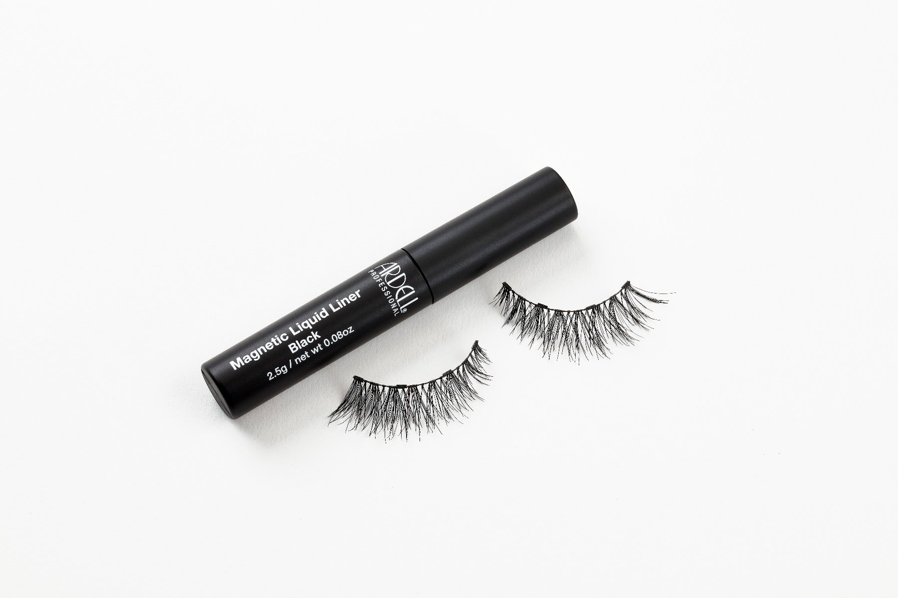 Capped Ardell Magnetic Liquid Liner bottle laying on its side with Accent Demi Wispies false lashes below