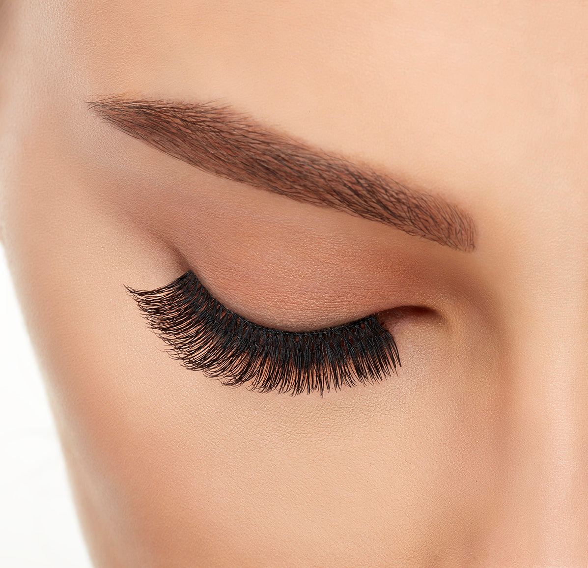 A model with closed eye wearing Ardell Studio Effects  105 with full volume, long length & natural lash look