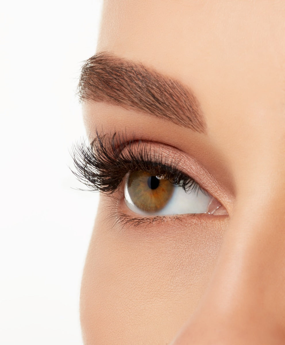 A close-up side shot of a model's eye wearing Ardell's Magnetic Lash 424, with shorter wispie lash with double layered curl