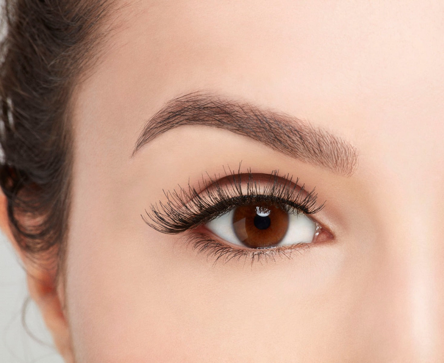 A model wearing Ardell Studio Effects Demi Wispies showing its enhanced winged effect and the undetectable lash band