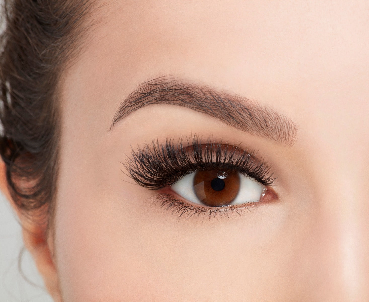 Close-up of a model's right eye wearing an Ardell Mega Volume 250 false lash showing its subtle winged out look