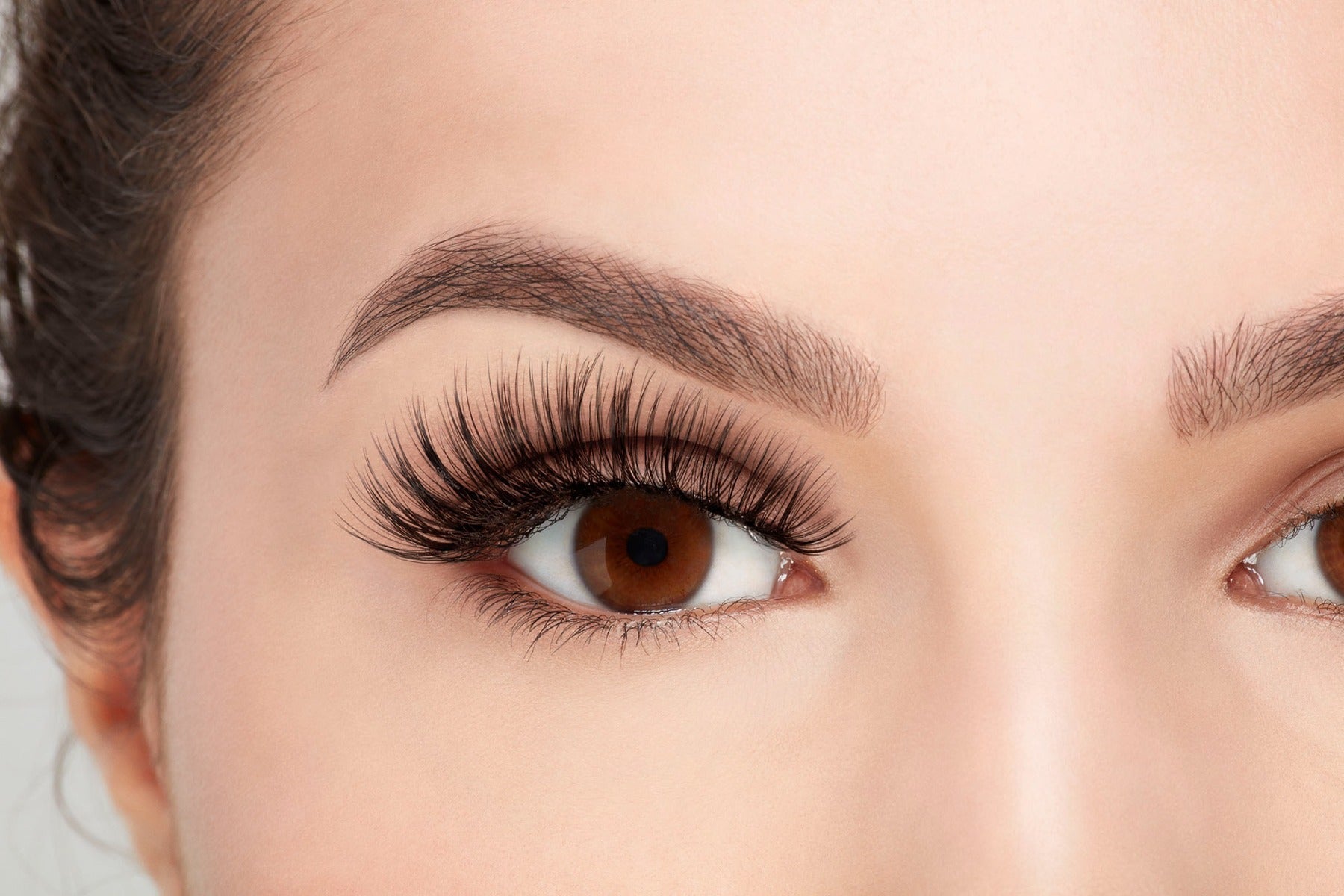 Front view of model with one eye open wearing Ardell 3D Faux Mink 853 to show how they look on the eye 