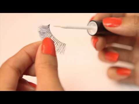 Hands using DUO Brush-On Lash Adhesive applicator for easy lash application.